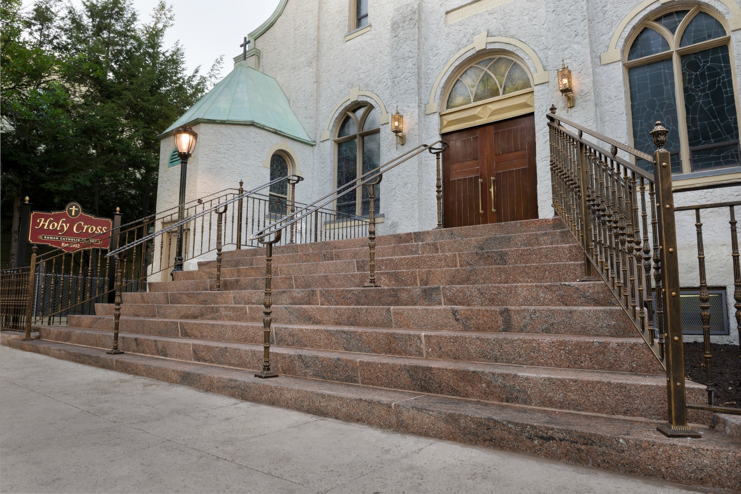 Intricate metal railings and marble steps at the main entrance of Holy Cross Church