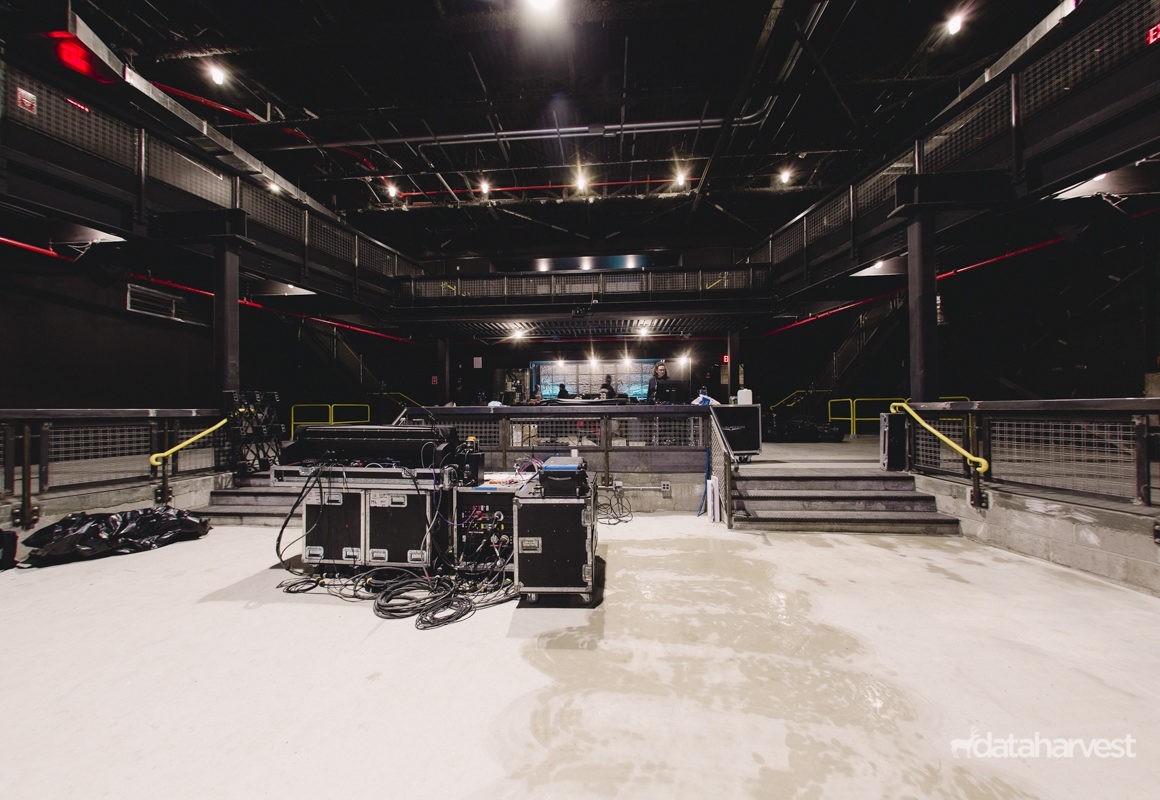 Mezzanine, bar, loft area, and sound engineer's work area at Brooklyn Steel featuring new steel installation, concrete floors, HVAC ducts, piping, sprinklers, lighting, railings, and soundproofing