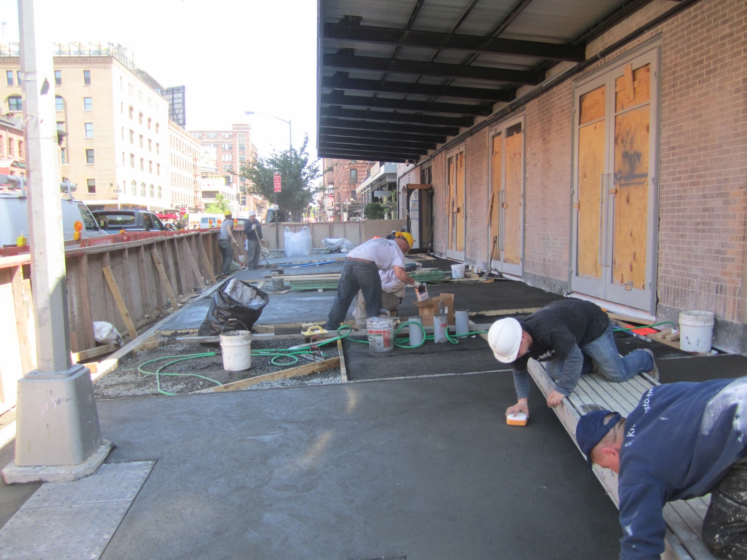 Street view of the completed sidewalk at 5 Little West 12th Street in Manhattan, where Jepol Construction applied a concrete topping slab for the final finish, showcasing the company's expertise in concrete work and waterproofing basement surfaces.