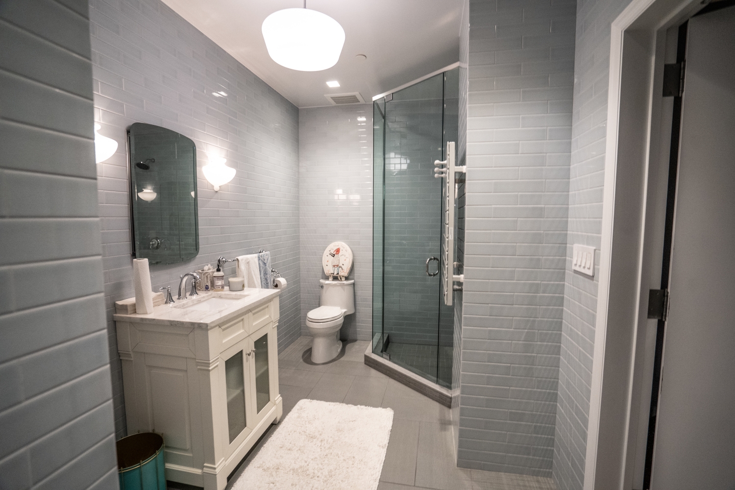 Renovated bathroom in a home showcasing a spacious walk-in shower, new wall and floor tiles, and modern fixtures