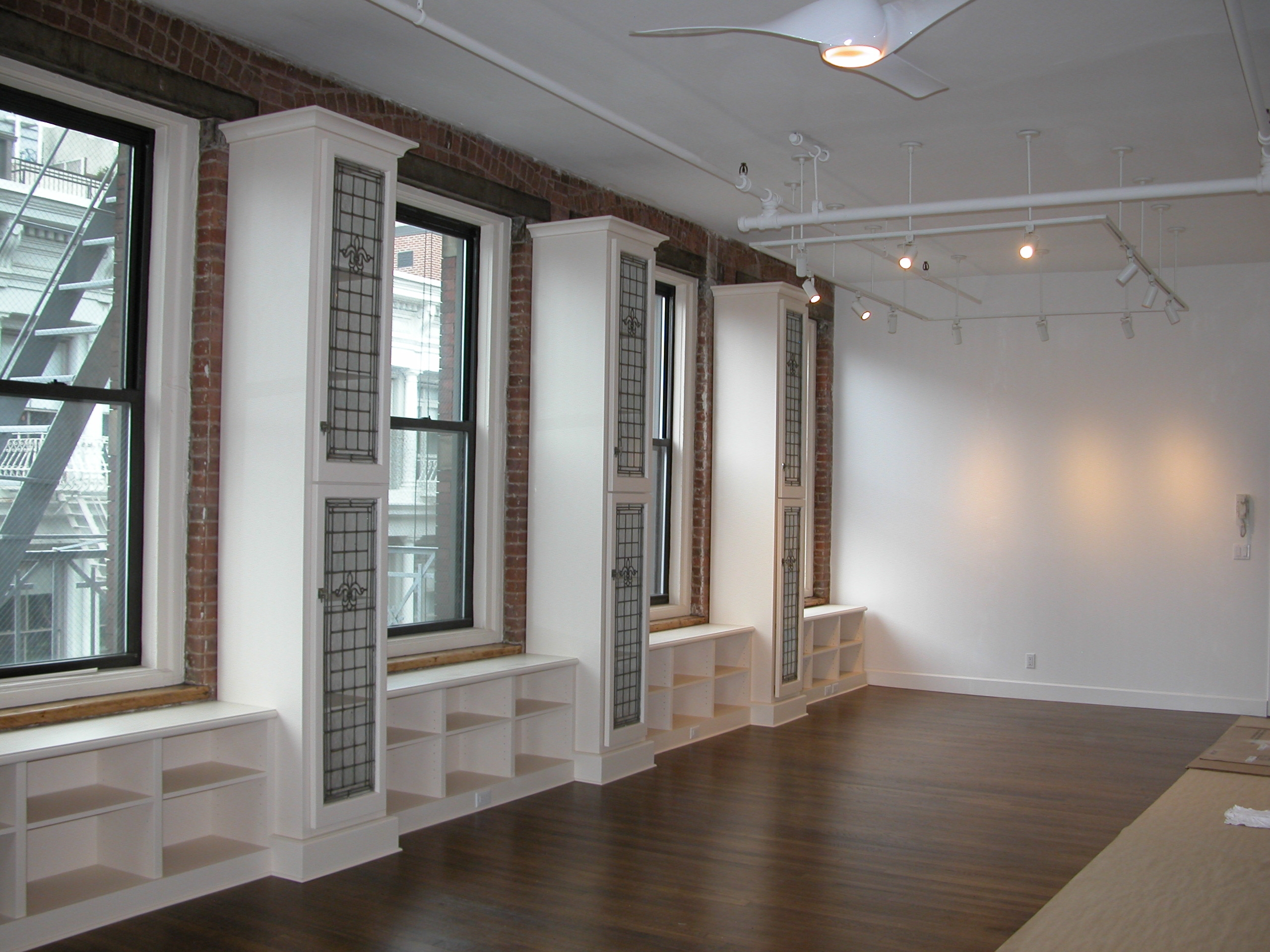 Interior view of an apartment at 80 White Street showcasing new windows, refinished flooring, new sprinklers, and freshly painted walls.