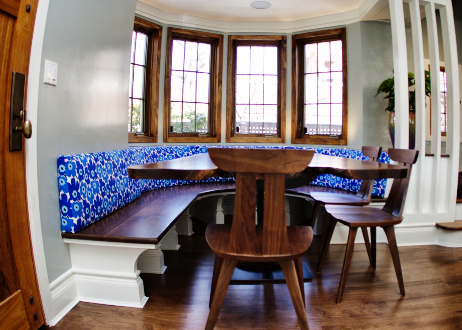 Renovated dining room in Forest Hills, Queens featuring a new bench, dining room table, wood window trims, painted walls, and a new wooden door