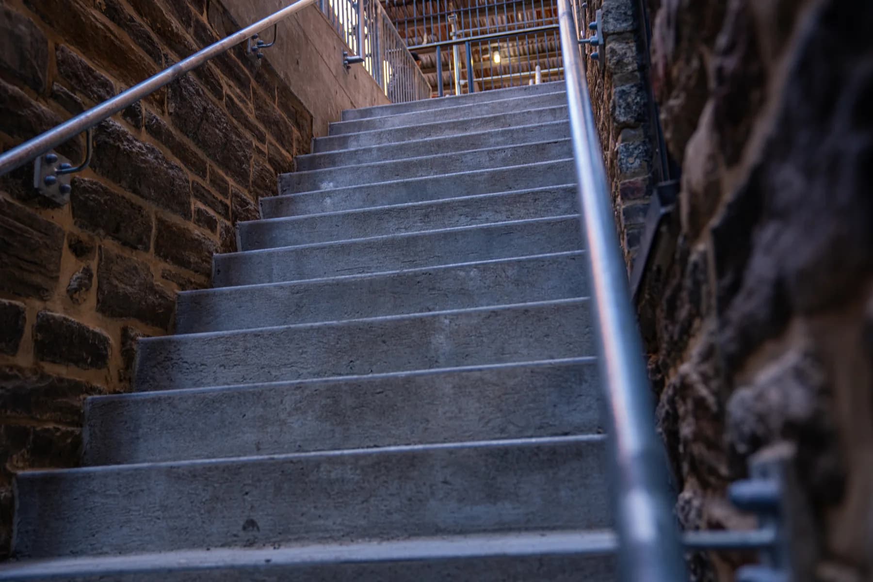 Symmetrical handrails installed along the completed stone stairs