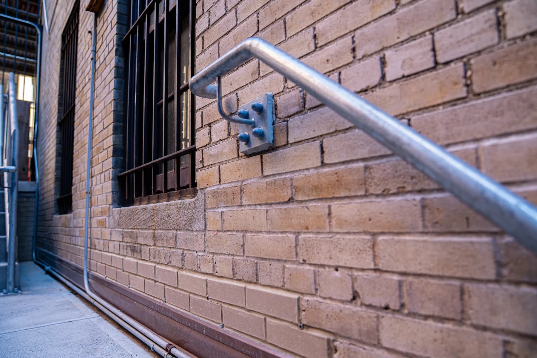 Wall-mounted handrail secured to the brick facade at 1088 Park Avenue