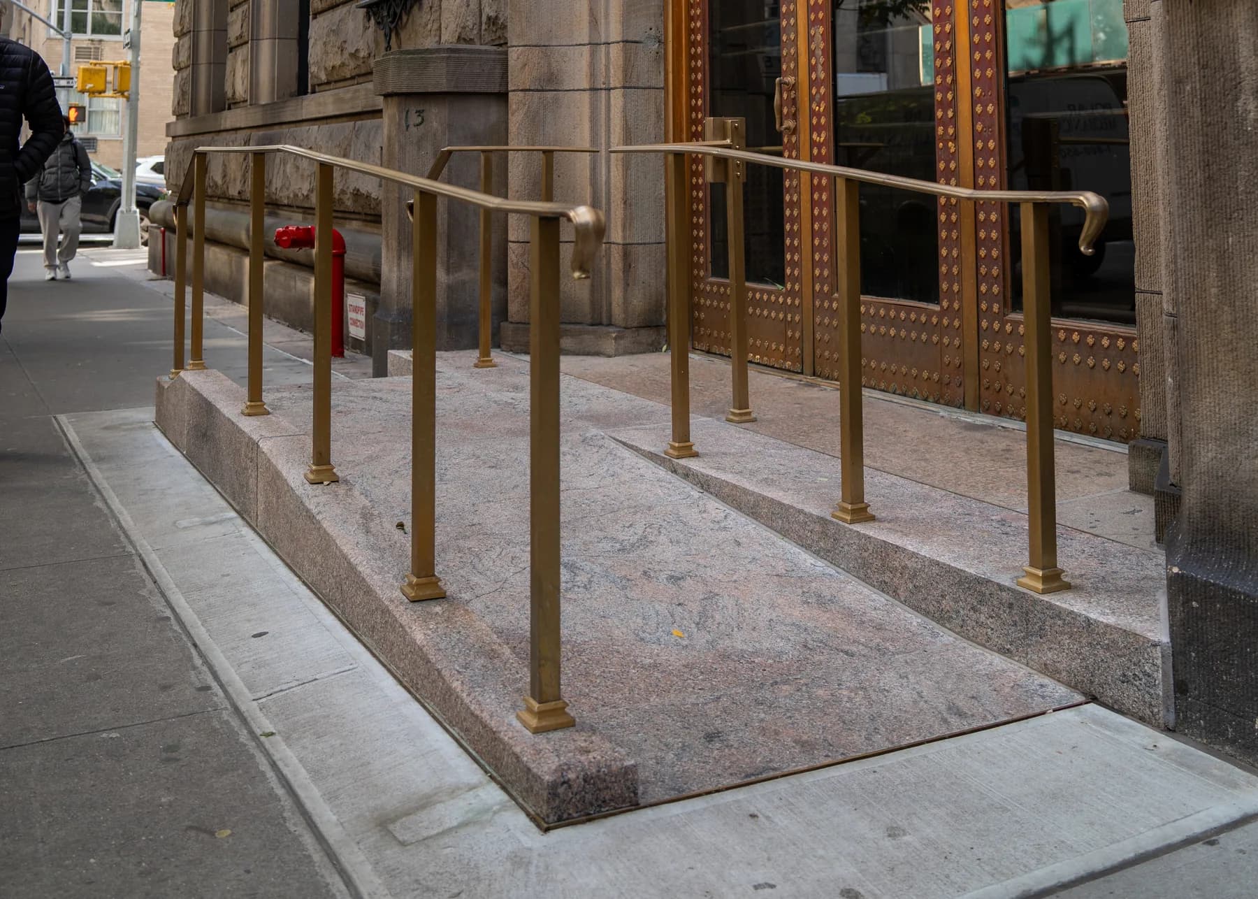 Bronze-toned railings around the accessible entrance platform