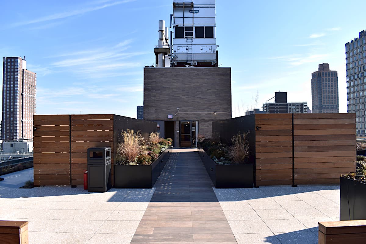 Rooftop circulation path framed by planters and Ipe screens