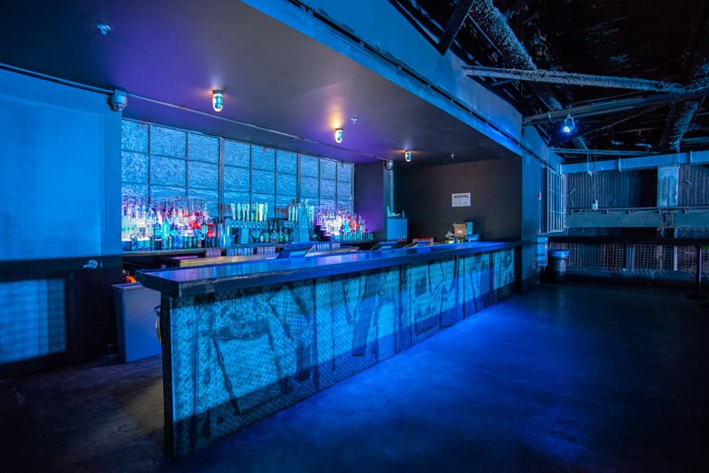 Custom bar with steel panels and glass-block backdrop