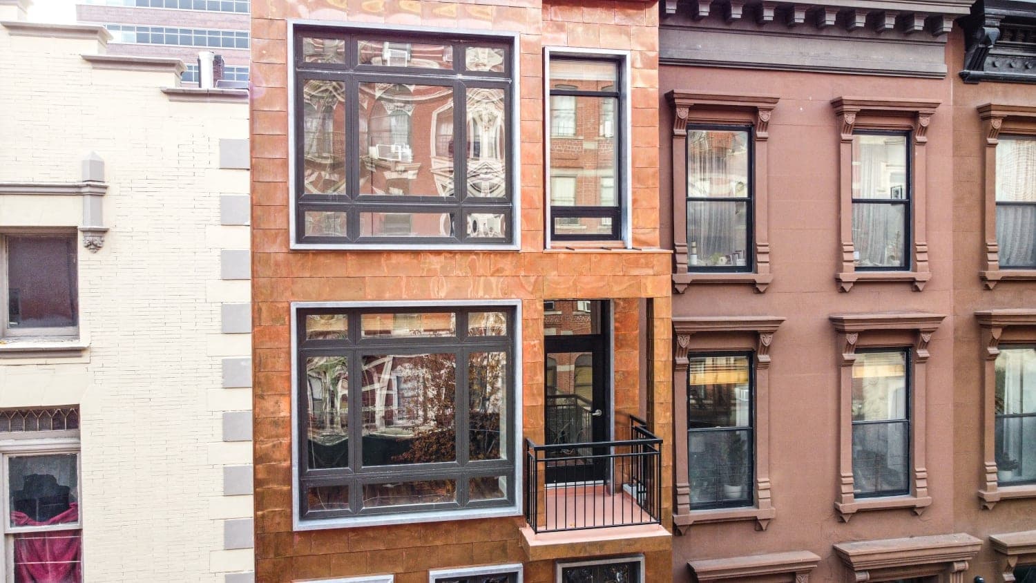 Upper façade windows, glazed door, and balcony railing