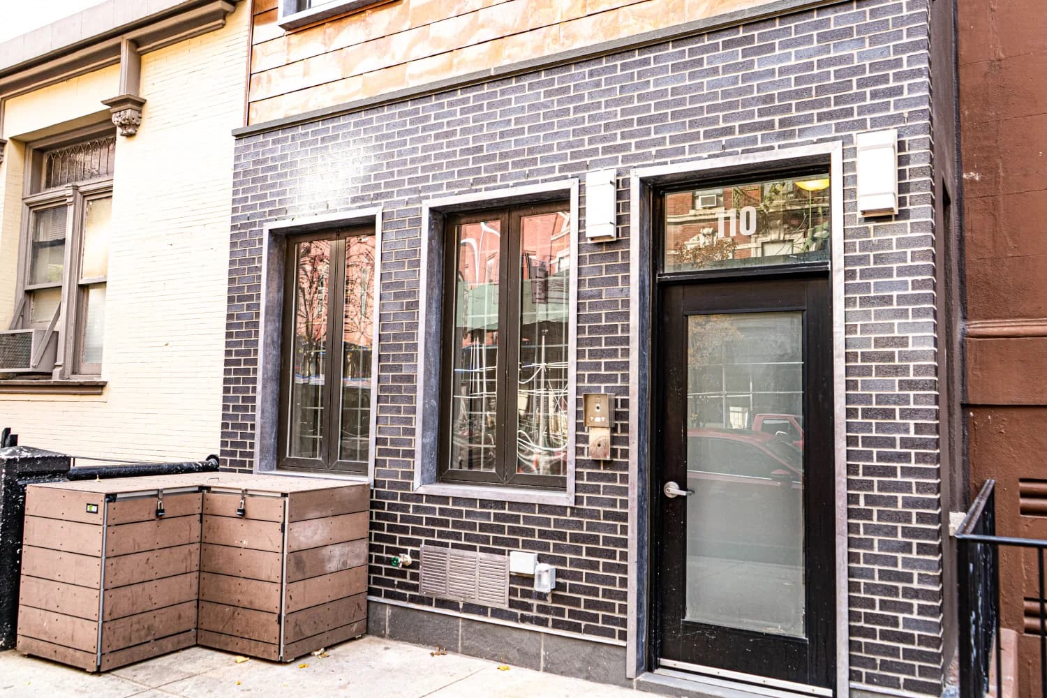 Street entrance, dark brick base, and metal-trimmed windows