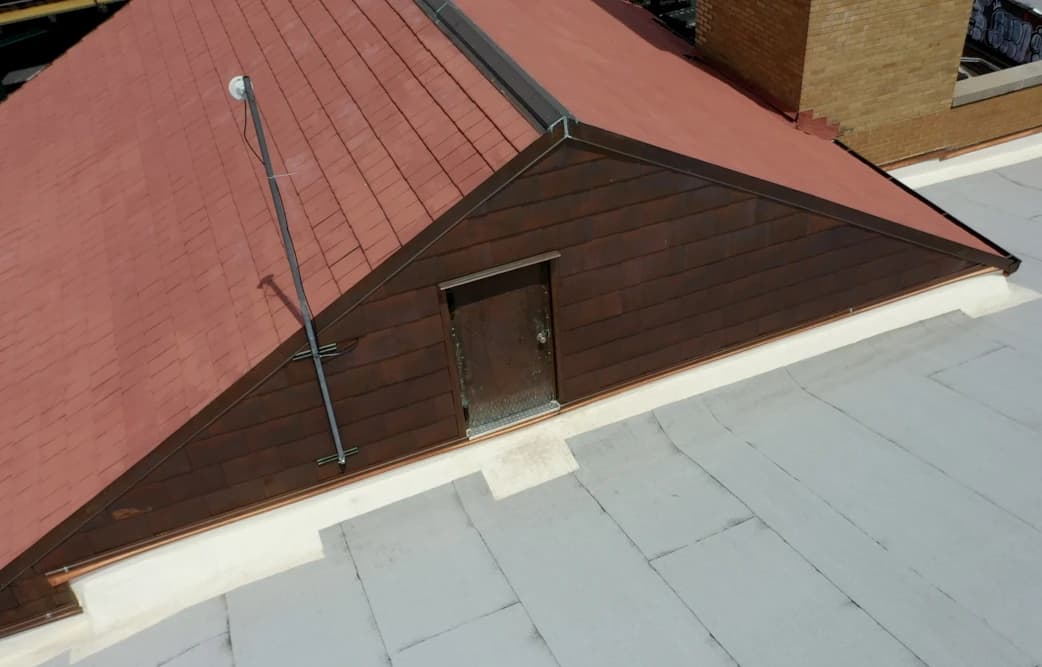 Roof transition and metal-clad structure above the church