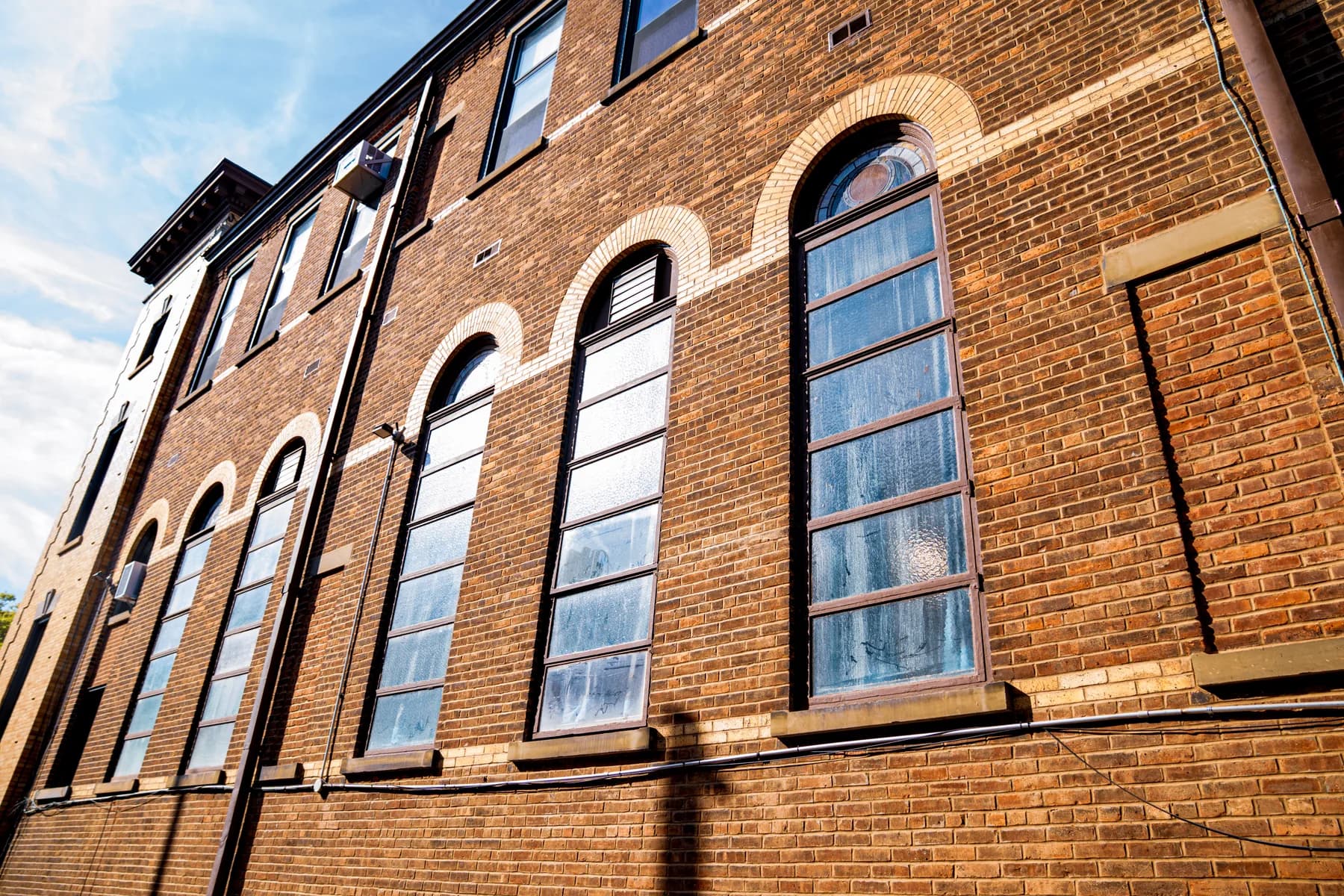 Restored brick facade and tall arched windows at St. Matthias RC Church