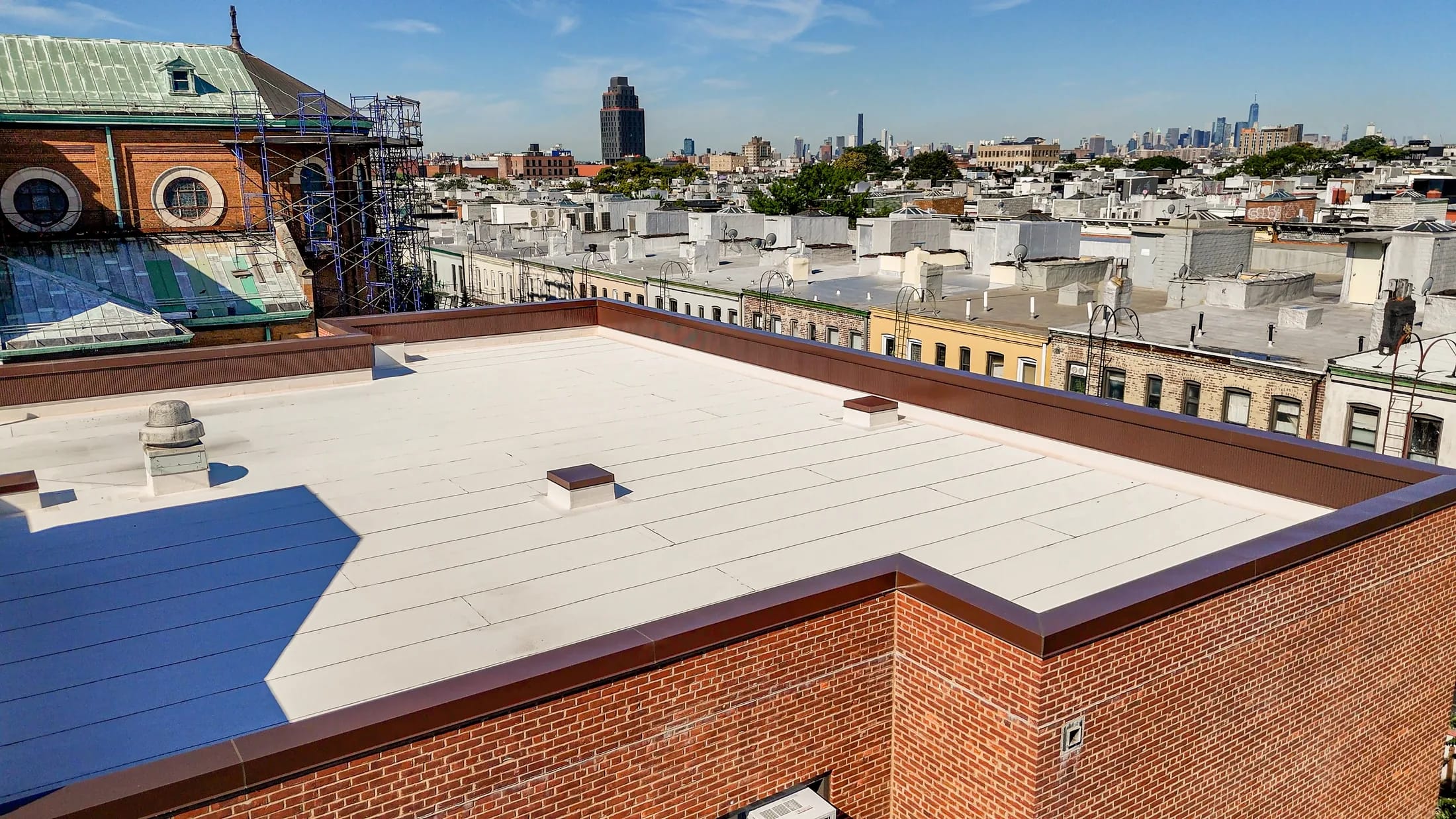 Completed roofing and parapet work overlooking the New York City skyline