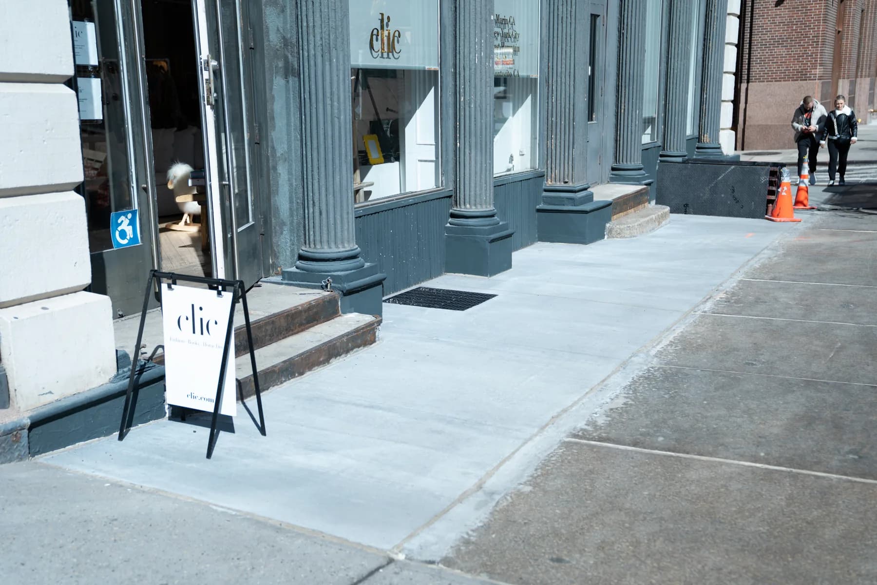 Completed concrete sidewalk extending along the facade at 140 Broadway