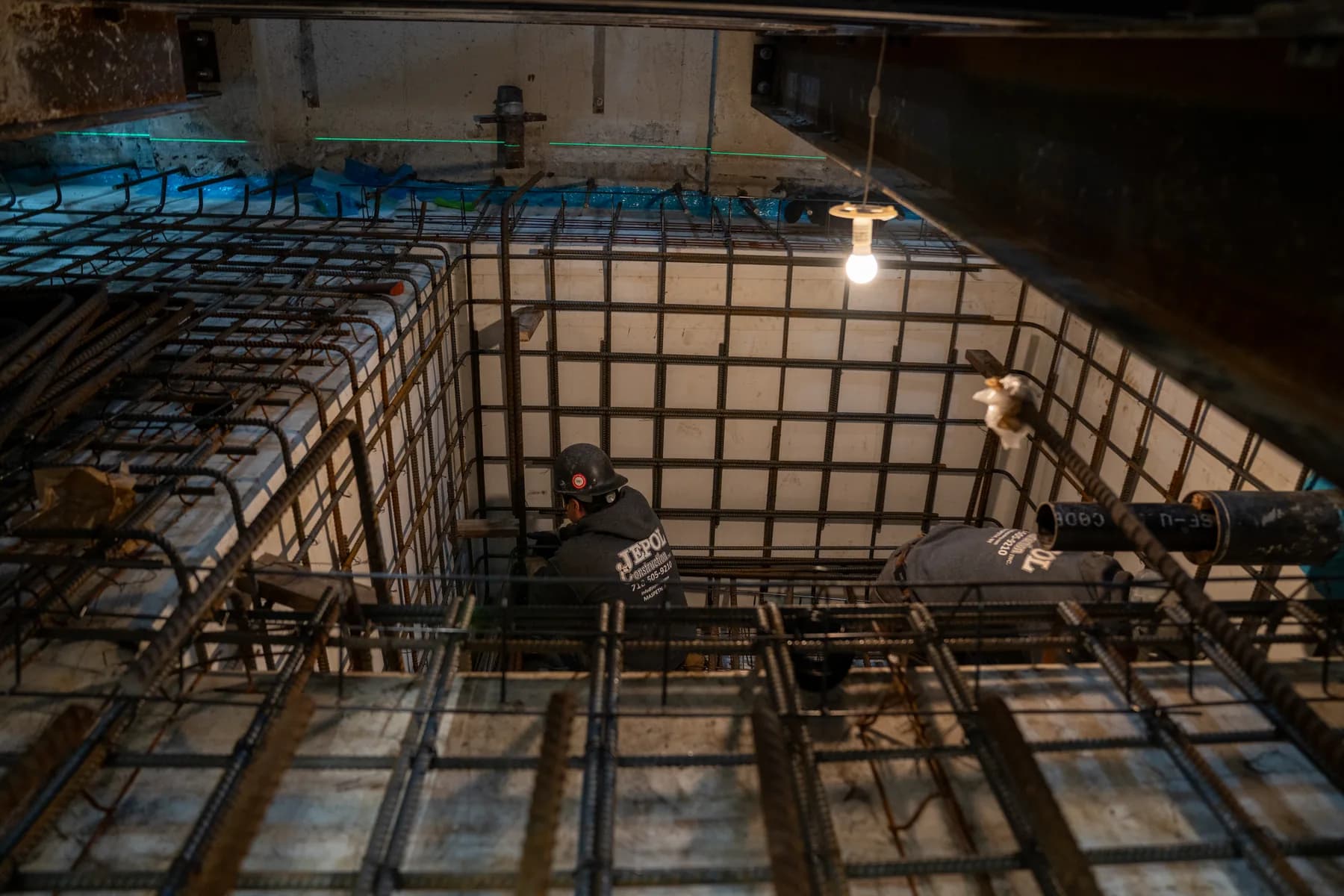 Rebar grid extending below electrical equipment in the service room