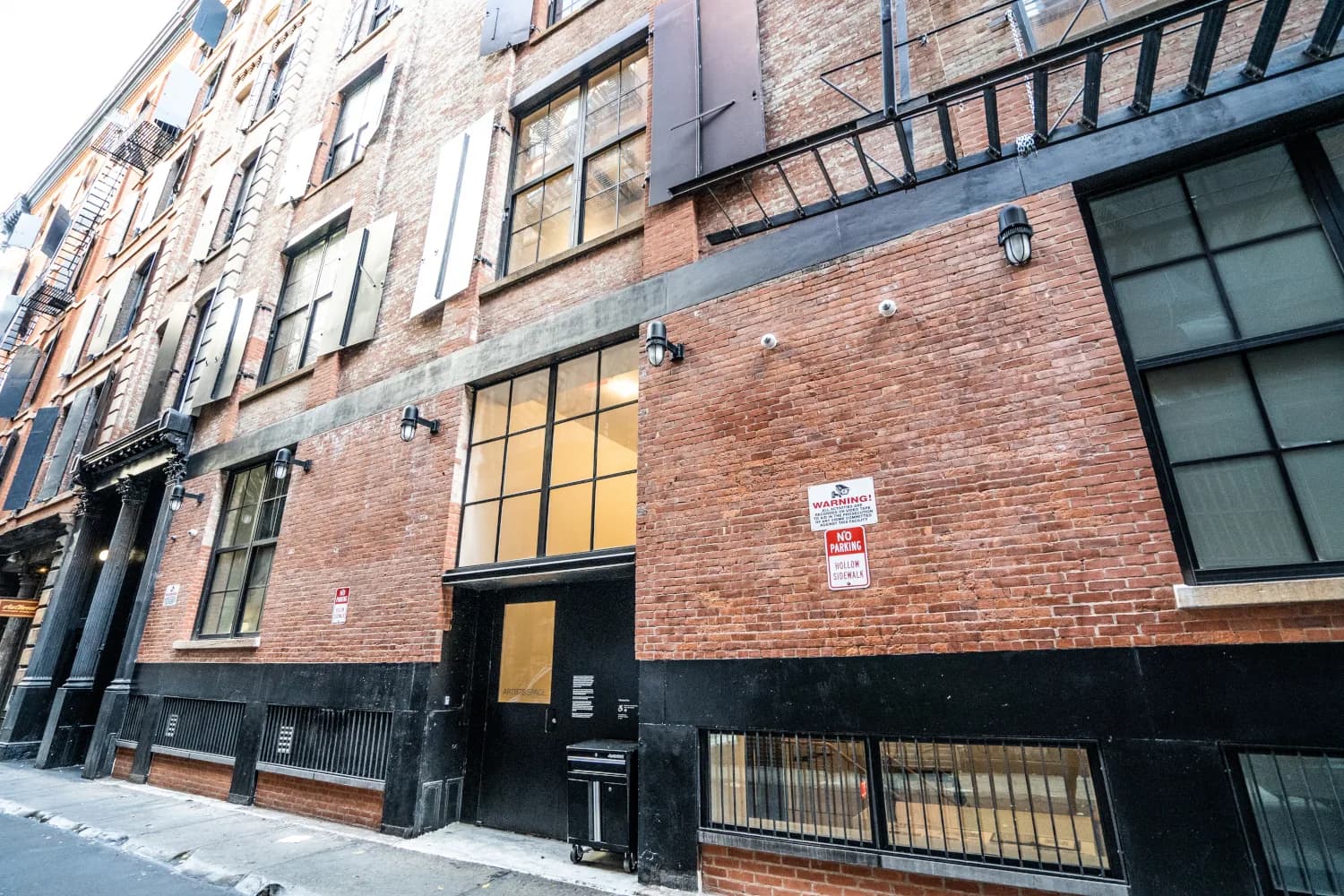 Restored brick side elevation with industrial windows and shutters