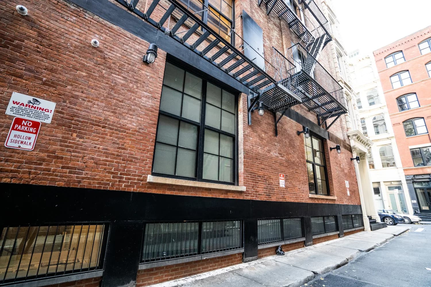 Restored brick elevation, industrial windows, and fire escape